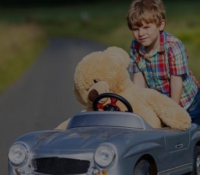 Child in childs car with teddy